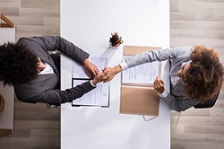 Two business people shake hands from above angle view