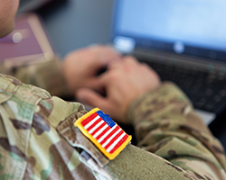 Military soldier working at a computer